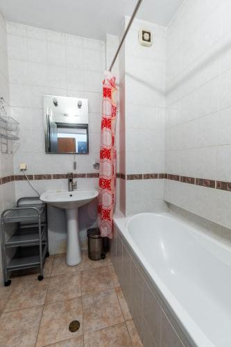 a bathroom with a bath tub and a sink at National Stadium 1BR by BulgarianHomes in Sofia