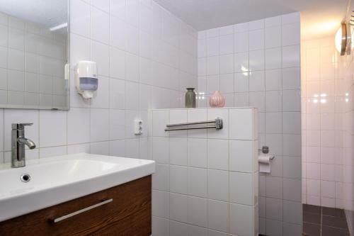 a white bathroom with a sink and a mirror at Stee in Stad in Groningen