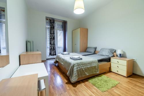 a bedroom with a bed and a dresser and window at National Stadium 1BR by BulgarianHomes in Sofia