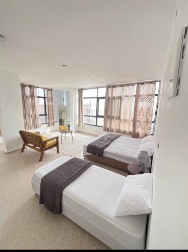 ein Hotelzimmer mit zwei Betten und einem Stuhl in der Unterkunft panorama villa boutique HT in Jericho