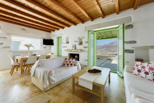 a living room with a couch and a table at Villa Aeolos with 2 private pools in Sarakíniko