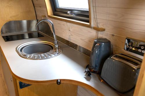 a kitchen counter with a sink and a window at Highland Gateway Glamping in Clackmannan
