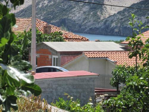 a house with a car parked in front of it at Apartmani Roza Lopar in Lopar