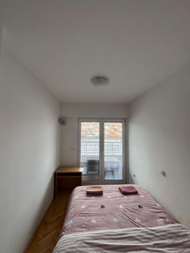 a bedroom with a large bed and a window at Apartman Harmony in Ohrid