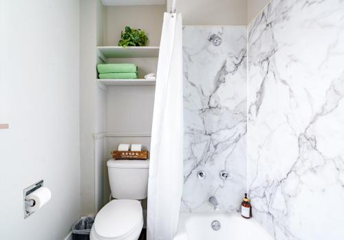 a bathroom with a marble shower curtain and a toilet at Jungle House Luxury Stays - Columbus Downtown Short North in Columbus