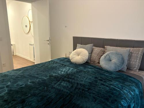 a bedroom with a large bed with blue pillows at Azure Living Apartman in Kragujevac