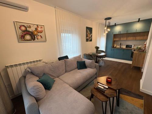 a living room with a couch and a table at Azure Living Apartman in Kragujevac