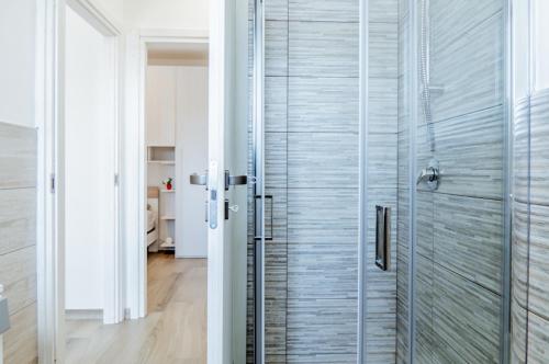 a bathroom with a shower with a glass door at Tabor Garden near Lake Maggiore by Kibilù Affitti Brevi in Golasecca