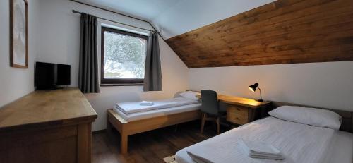a small room with a desk and a bed and a desk at Chata Krpko in Horná Lehota