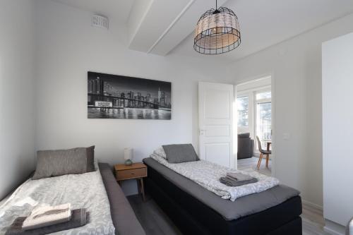 a bedroom with two beds and a chandelier at Pramea Apartments Tourula in Jyväskylä