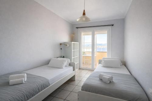 two beds in a room with a window at The Tree House Coliving in El Médano