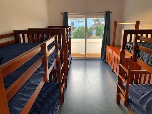 a room with four bunk beds and a window at Murthy Surf School in Covelong