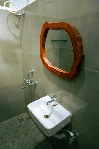 a bathroom with a sink and a mirror on the wall at Murthy Surf School in Covelong