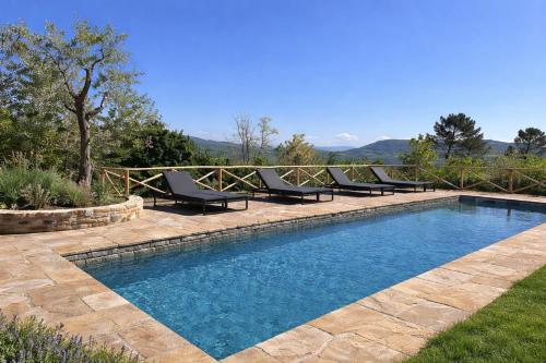 a swimming pool with lounge chairs next to a fence at Villa Gianotti by MMega in Lugnano