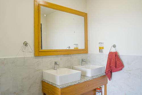 a bathroom with two white sinks and a mirror at Qudrat - Boutique Hostel & Cafe in Bīr