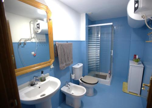 a blue bathroom with a sink and a toilet at Modern Flat in Guejar Sierra in Güéjar-Sierra