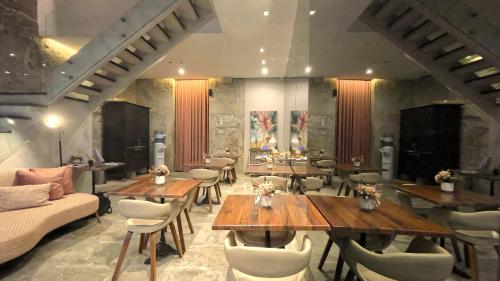 a restaurant with wooden tables and chairs and a couch at CHARM by YoursPorto in Vila Nova de Gaia