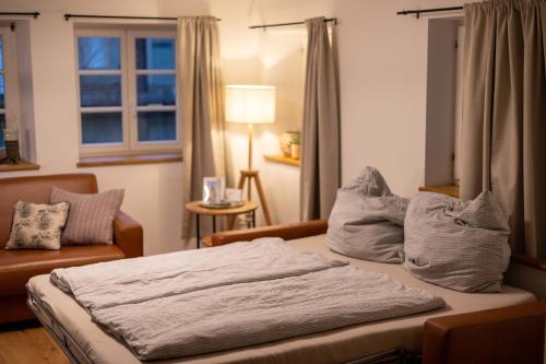 ein Schlafzimmer mit einem Bett, einer Couch und einem Fenster in der Unterkunft Concordia33 - Traumferienwohnung an der Regnitz in Bamberg