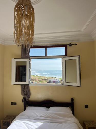 a bedroom with a bed and a large window at Ocean Nomads hostel Taghazout in Taghazout