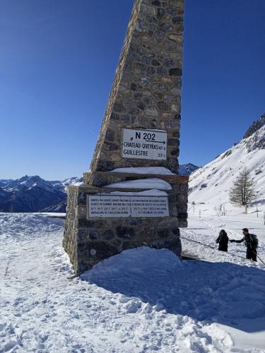 ein Schild auf einem Steinturm im Schnee in der Unterkunft Chambrecentre in Briançon