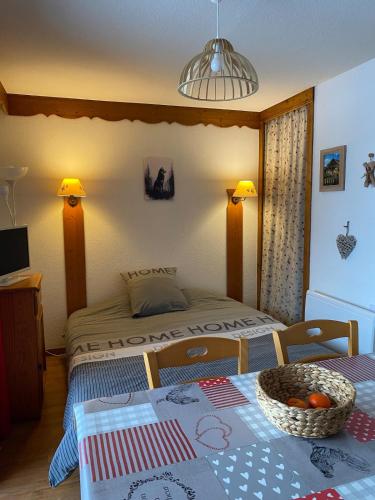 a bedroom with a bed and a table with a bowl of fruit on it at T2 cosy 4 pers balcon vue montagne la Joue du loup in Le Dévoluy