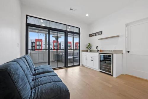 a living room with a blue couch and a kitchen at Jungle House Luxury Homes - Columbus Downtown Short North - Near Convention Center & Nationwide Arena - Sleeps up to 15 - Free Parking - Over 5,800 Five Stars in Columbus