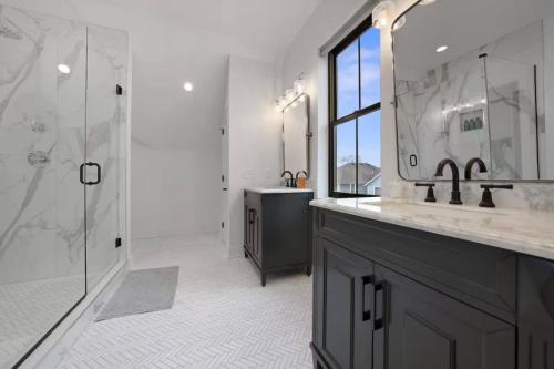 a bathroom with two sinks and a shower and a mirror at Jungle House Luxury Homes - Columbus Downtown Short North - Near Convention Center & Nationwide Arena - Sleeps up to 15 - Free Parking - Over 5,800 Five Stars in Columbus