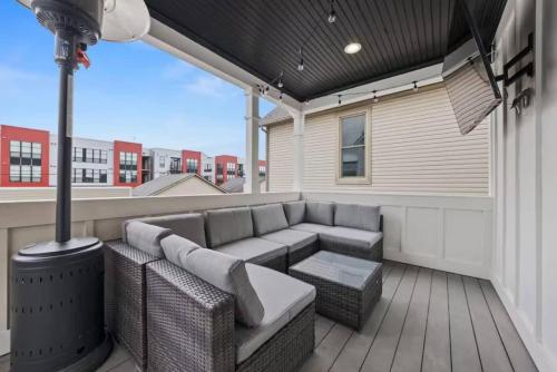 a patio with a couch and a table on a deck at Jungle House Luxury Homes - Columbus Downtown Short North - Near Convention Center & Nationwide Arena - Sleeps up to 15 - Free Parking - Over 5,800 Five Stars in Columbus