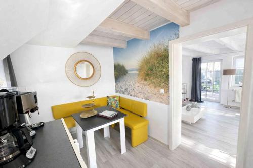 a living room with a yellow couch and a table at "Huus ant Diek", Ferienhaus mit Maisonette Wohnung in Deichnähe, Nähe Norddeich in Norden