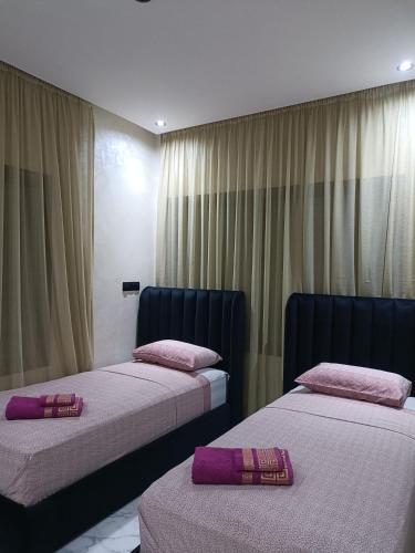 two beds in a room with pink pillows on them at Résidence Escalade 1 in El Jadida