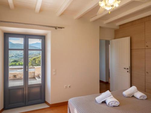 a bedroom with a bed and a large window at Paros Tranquility Villa in Dhragoulás