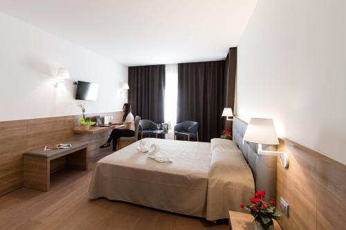 a hotel room with a bed and a desk at Albergo Al Tarcentino in Tarcento