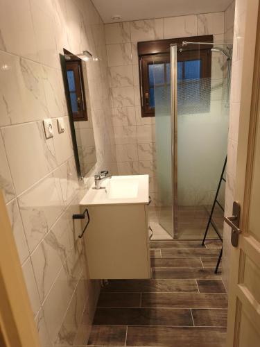 a bathroom with a sink and a shower at Maison Chez Papy Chapeau 4 étoiles in Leuvrigny