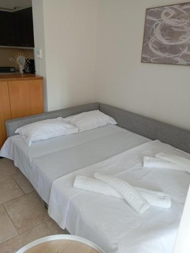 a large white bed with two white pillows on it at Apartment Akanthous in Kallithea Halkidikis
