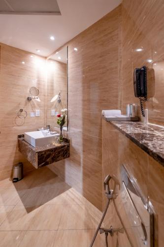 a bathroom with a sink and a mirror at Peony Hotel in Dubai