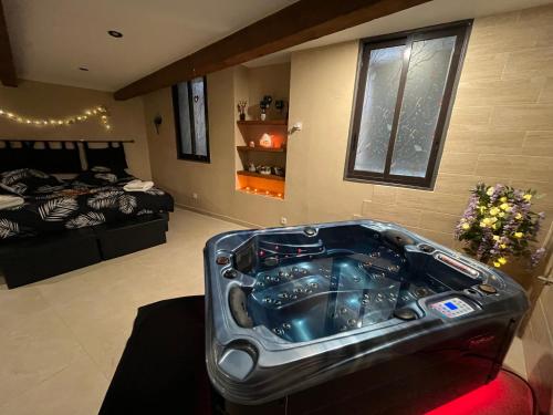 a room with a bathtub in the middle of a room at Le Cocon SPA Évasion Privée - jacuzzi - in Lunel