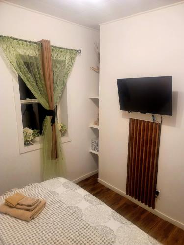 a bedroom with a bed and a flat screen tv at Warm cozy 1 bdrm close to Hwy in Edmundston