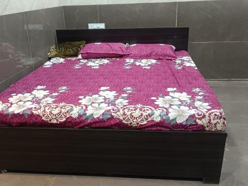 a bed with a purple and white comforter on it at Ram Hari Hara Convention in Khammam