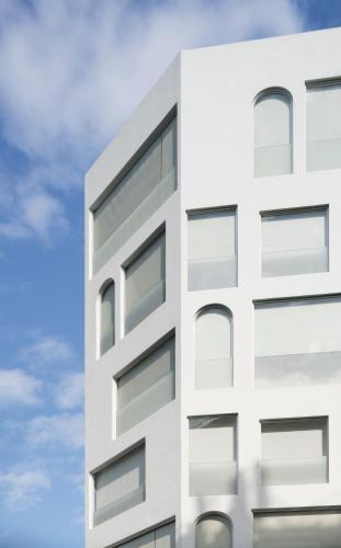 a white building against a blue sky at Swiio Hotel Daan in Taipei