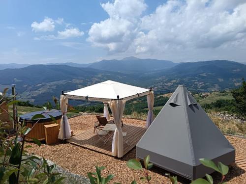 a tent and a chair on a wooden deck with a view at La Torre in Pavullo nel Frignano