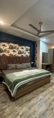 a bedroom with a large bed with a ceiling fan at Sakhiya Fish Resort Pvt Ltd in Chhapia