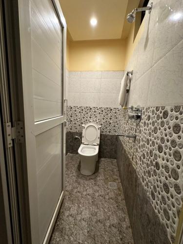 a small bathroom with a toilet and a shower at Sakhiya Fish Resort Pvt Ltd in Chhapia