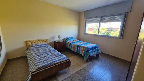 a bedroom with two beds and a window at El Tesoro Cordobés in Córdoba