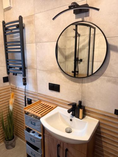 a bathroom with a sink and a mirror at Domek pod Głazami in Ostre