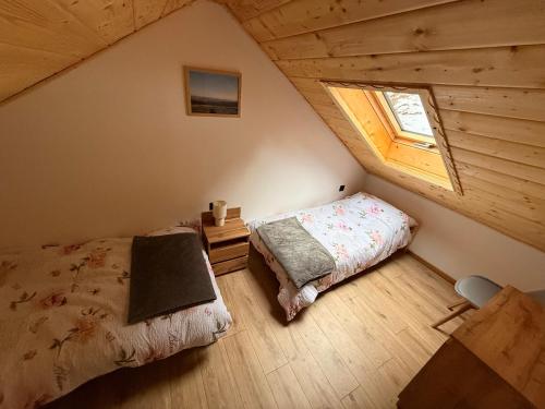 an attic bedroom with a bed and a window at Domek pod Głazami in Ostre