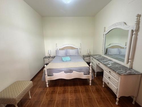 a bedroom with a bed and a dresser with a mirror at Elisabeth House in Ponta do Sol