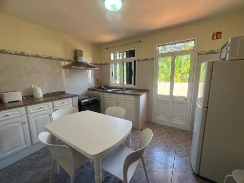 a kitchen with a white table and a white refrigerator at Elisabeth House in Ponta do Sol