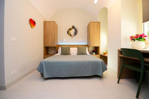 a bedroom with a bed and a table with a vase of flowers at Dimora del Cuore GUEST HOUSE IN Centro in Vieste