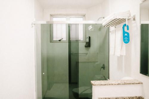 a shower with a glass door in a bathroom at Aguas do Iguaçu Hotel Centro in Foz do Iguaçu