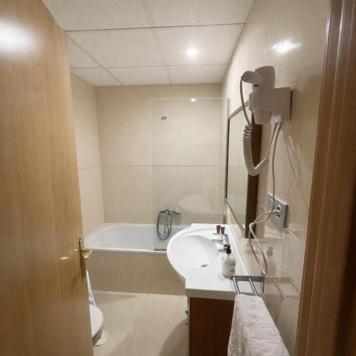 a bathroom with a sink and a bath tub at Hotel Molí Beach in Benidorm